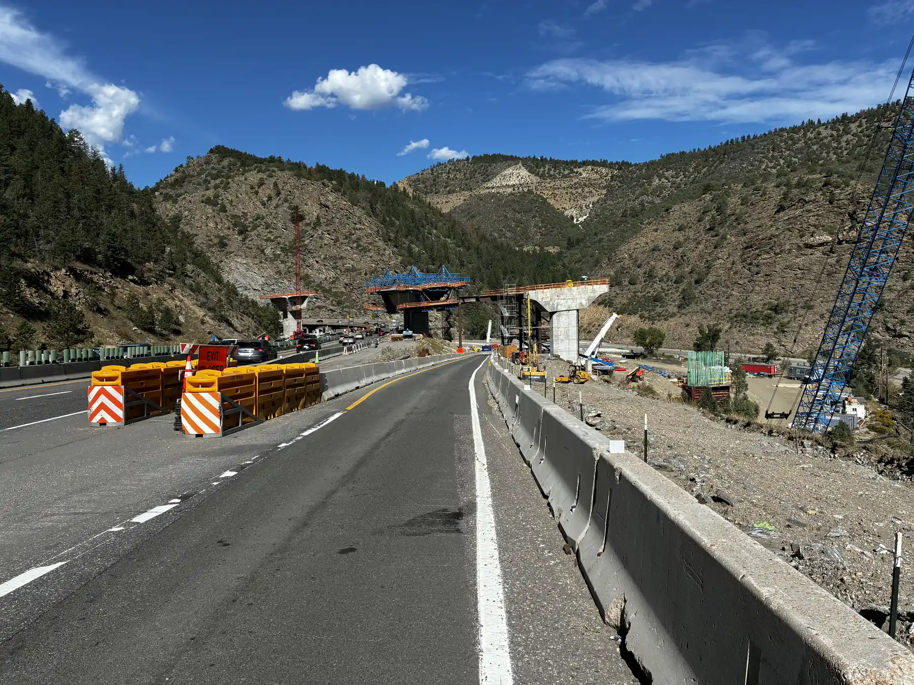 Existing I-70 traffic beside new bridge construction at the Floyd Hill project in Colorado