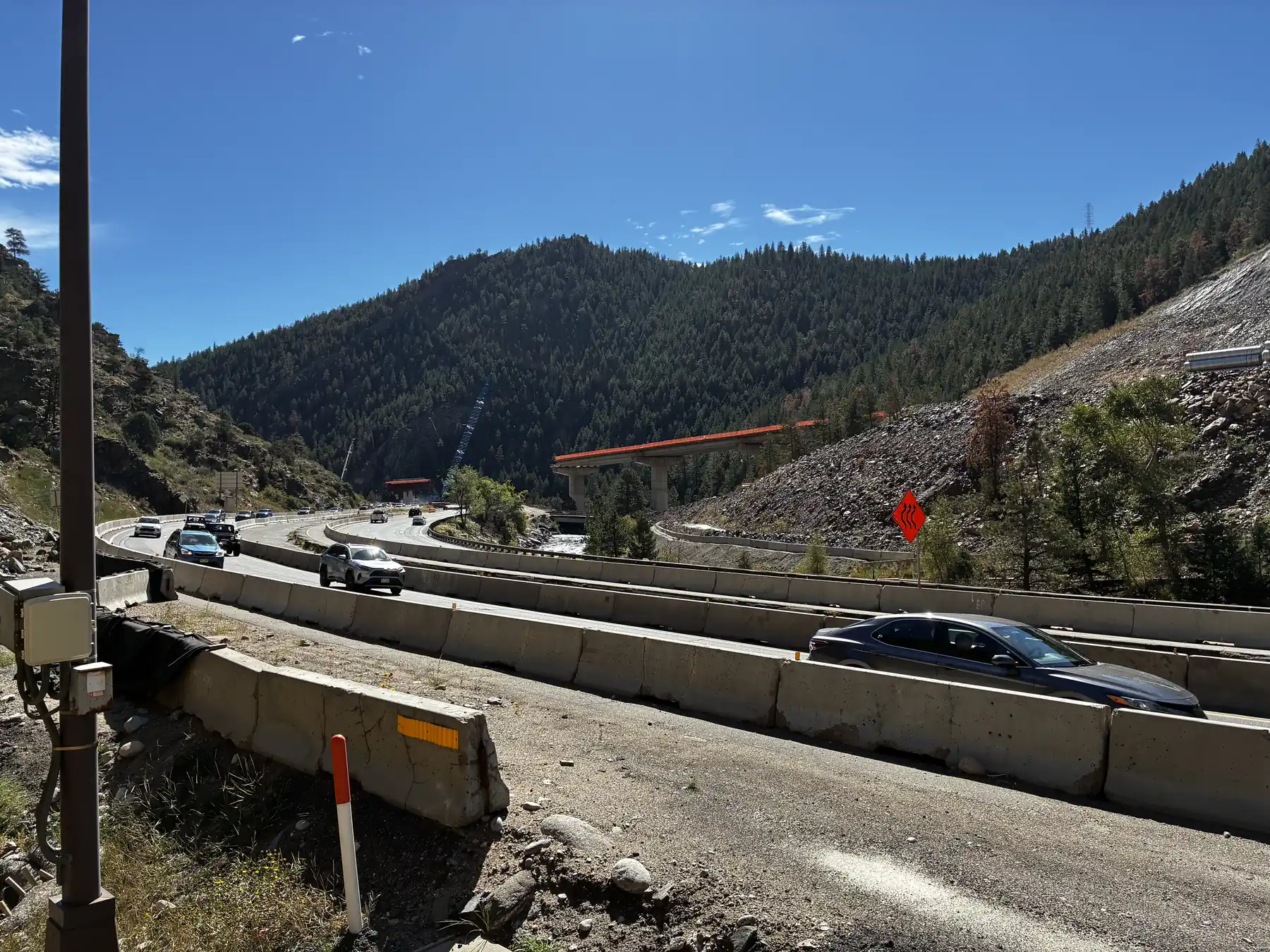 I-70 traffic curving past the new bridge overpass under construction at Floyd Hill, Colorado