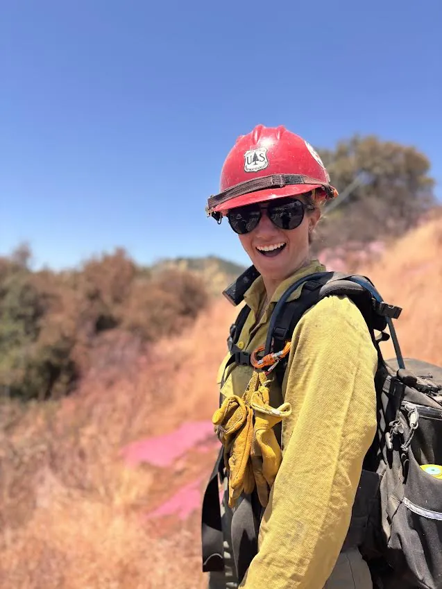 Senna Sink in a US Forest Service hard hat and wildland firefighting gear on a fire line in the Tetons